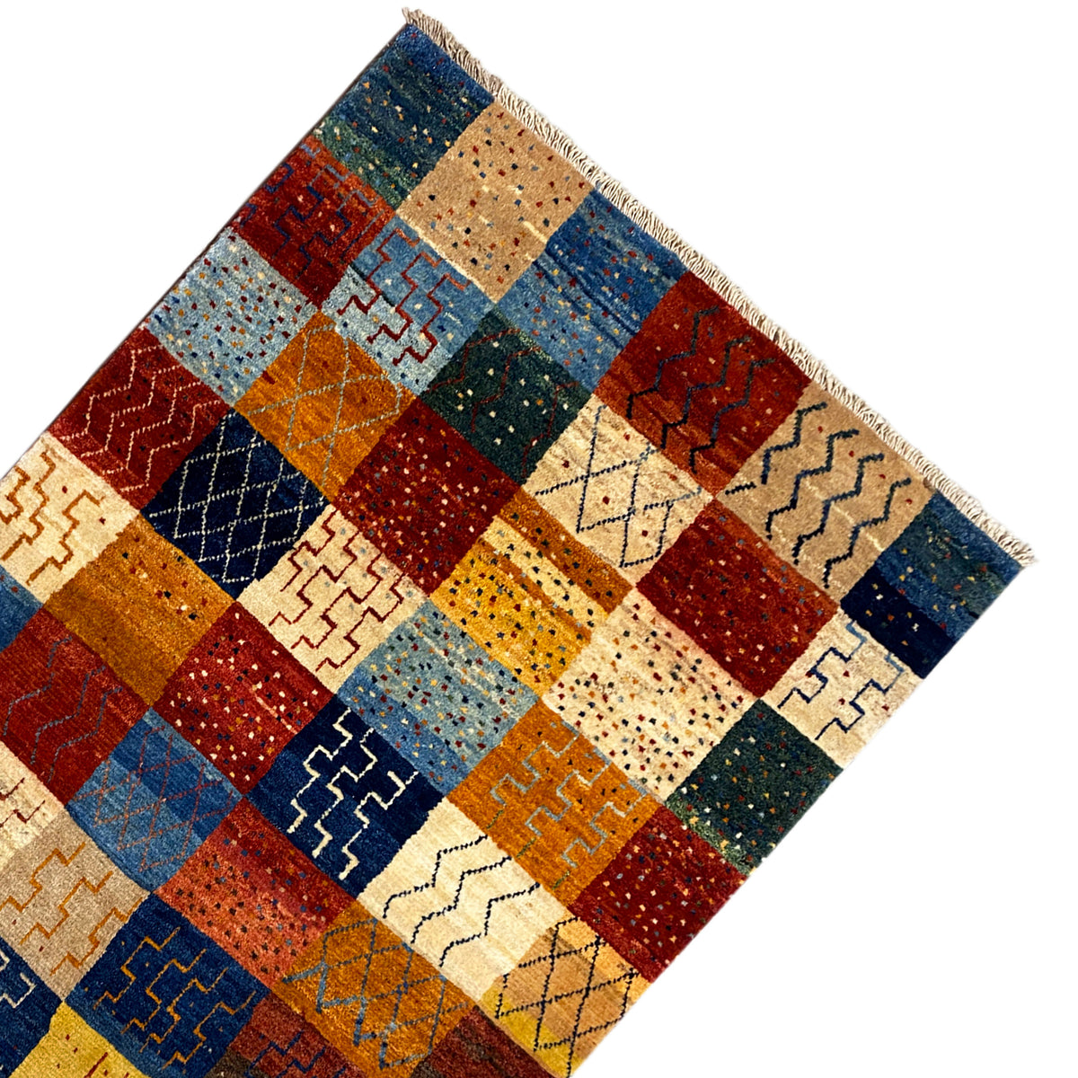Gabbeh rug in perspective: patchwork with dark blue and red sections and patterned diamonds