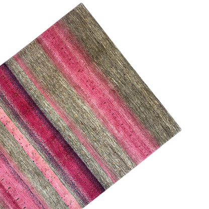 Gabbeh rug, photographed at an angle: pink stripes between gray stripes, textured pile
