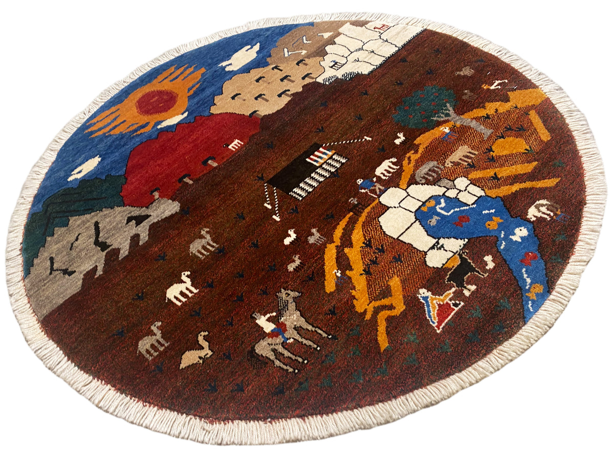 Runder Gabbeh-Teppich mit Landschaftsmotiv in Blau, Rot und Braun, naturfarbener Kante