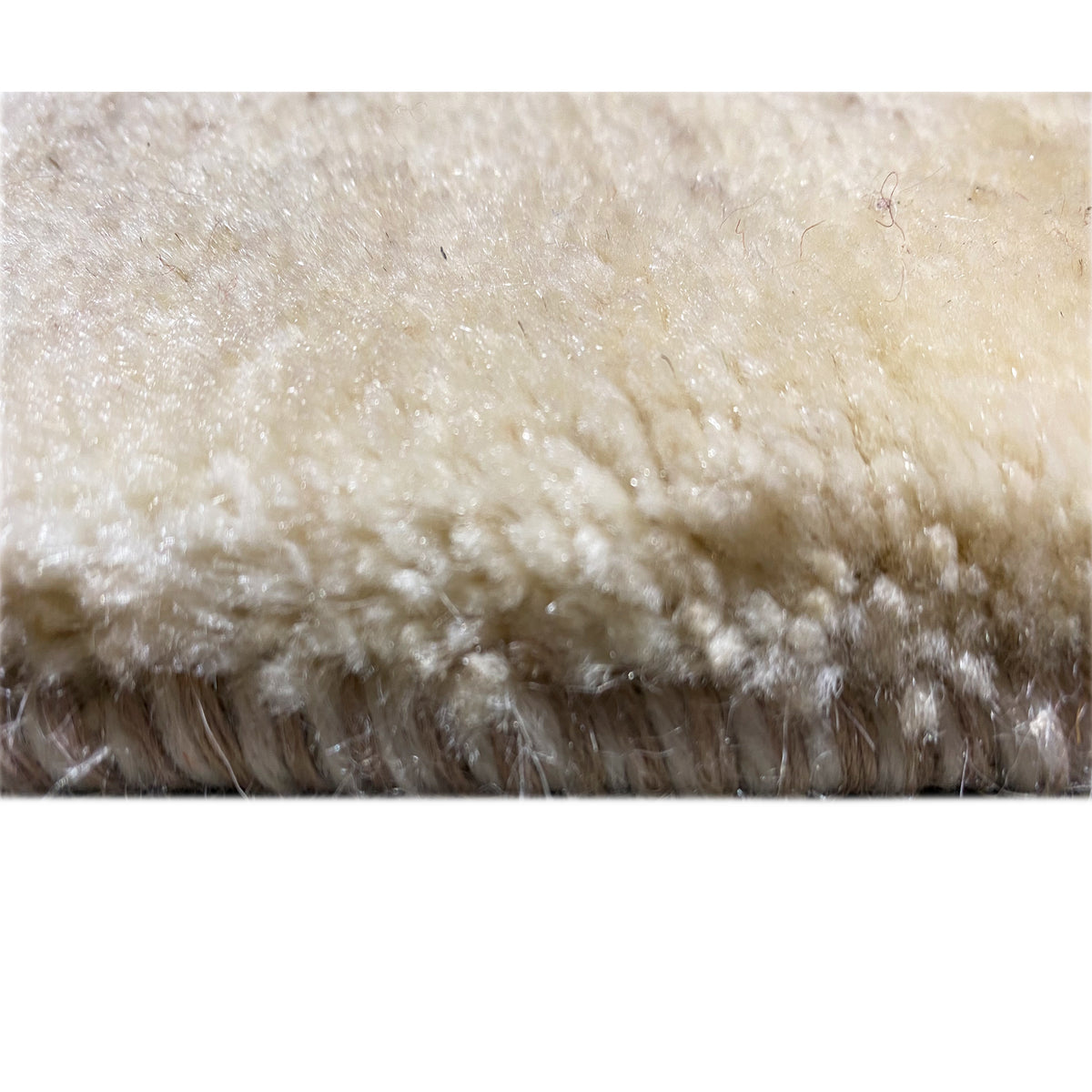 Close-up of a Gabbeh rug's pile and fringe edge, light beige with a short pile