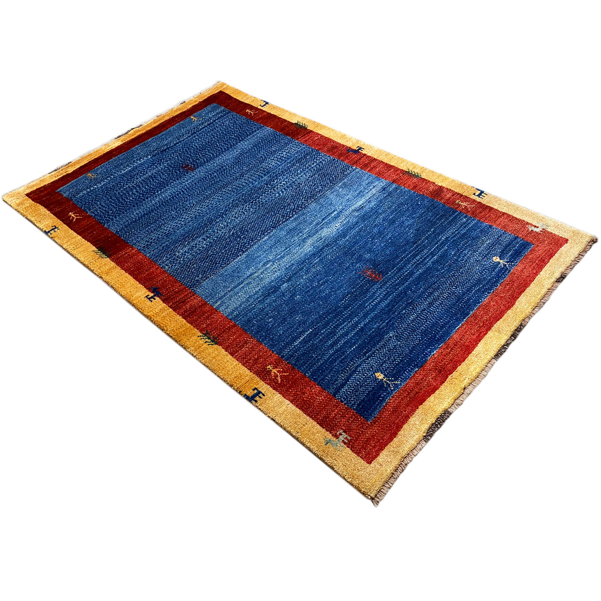 Rug in diagonal pattern: blue, red center border, beige edge with small motifs