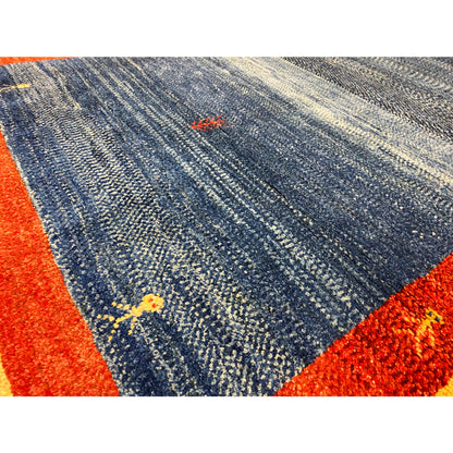 Close-up of carpet pile: blue-gray texture, red border, and fine patterned dots