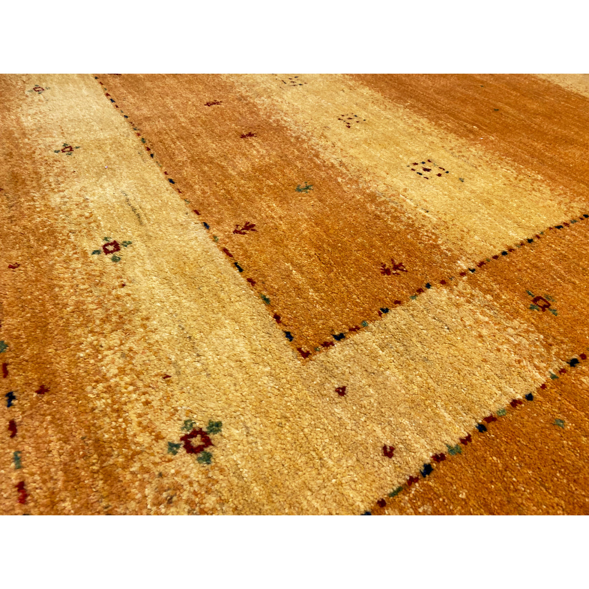 Rug detail: ochre-colored area with fine thread markings and small multicolored dots