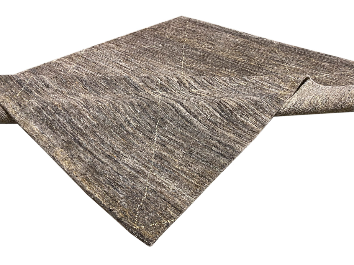Teppich mit diagonaler Linienführung, grau-beiger Melange-Ton und sichtbarer Musterkante.