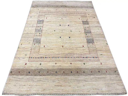 Gabbeh rug laid flat: light beige field with a wide geometric border