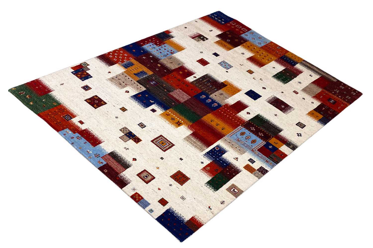 Gabbeh rug with a geometric patchwork pattern in red, blue, green, and dark brown on a light background