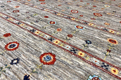 Gabbeh rug detail view: small circular ornaments and colorful flowers on a gray background
