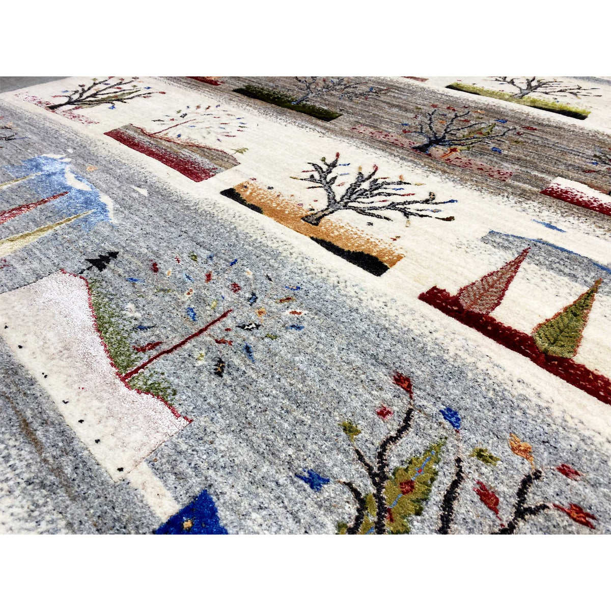 Close-up of a Gabbeh rug: gray areas with embroidered trees and colored dots