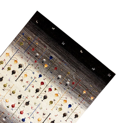Gabbeh rug at an angle: natural background with colorful animal motifs, dark longitudinal border.