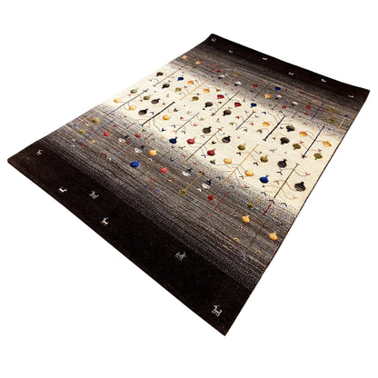Gabbeh rug at an angle: light field with colorful motifs and lines, dark border.