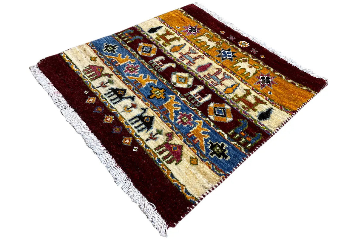 Gabbeh rug 63x58 cm, spread at an angle, multicolored ornamental field and fringes.