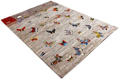 Gabbeh rug in diagonal view, light gray with colorful butterflies