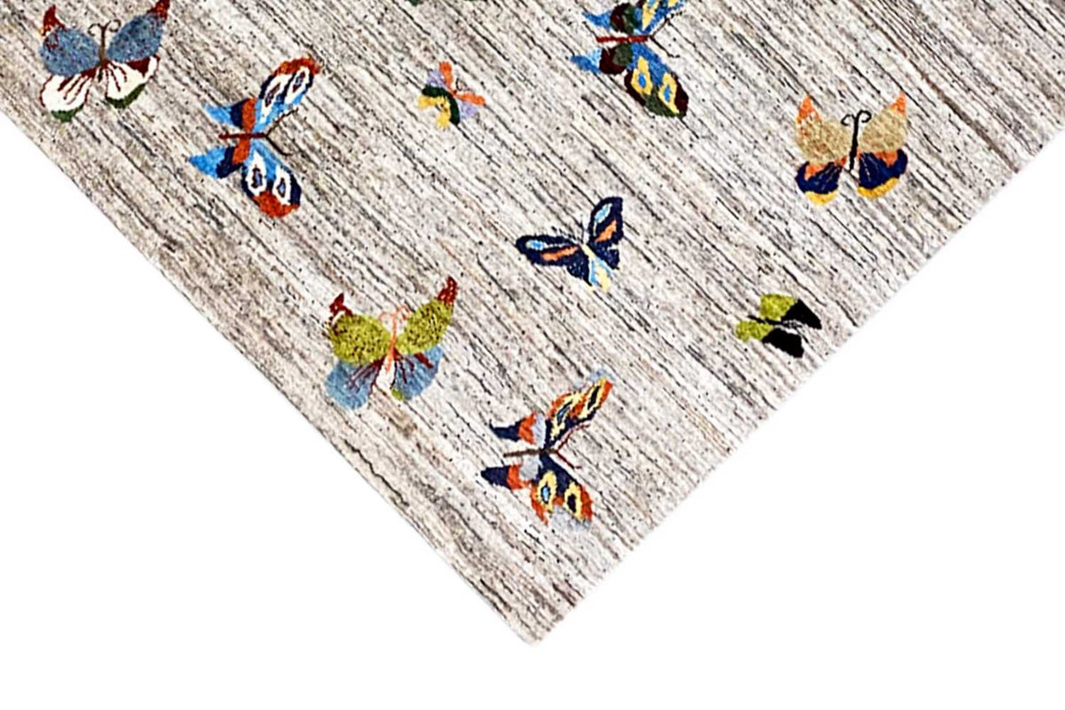 Gabbeh rug with colorful butterflies on a light, mottled background