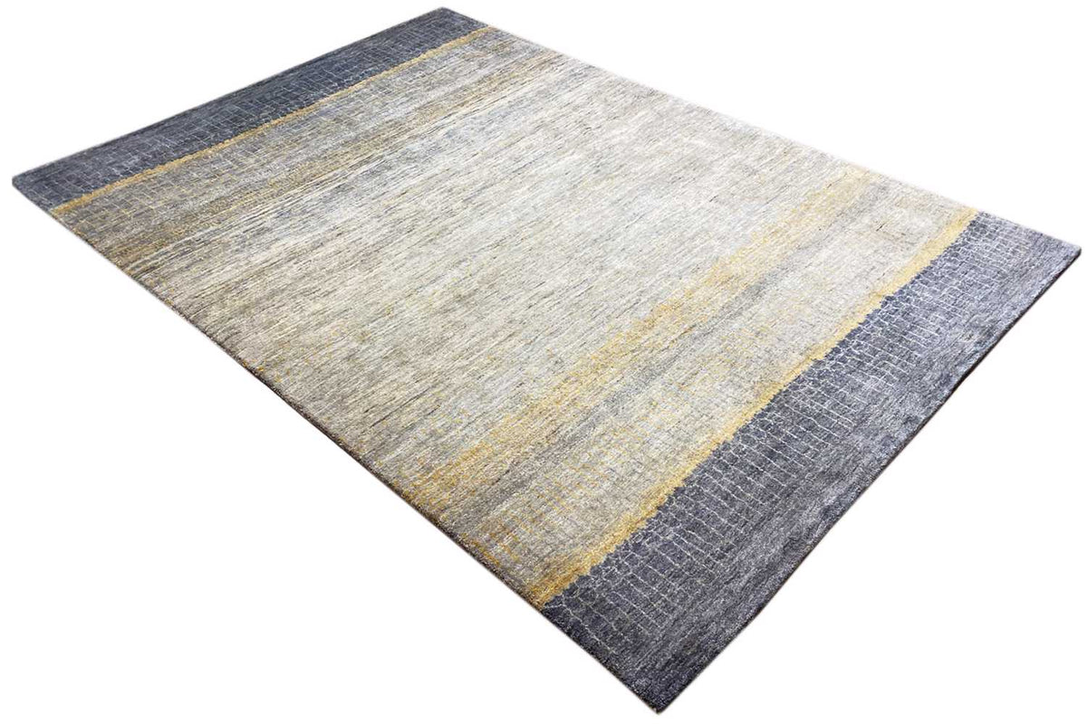 Gabbeh-Lori rug, photographed at an angle: light gray with yellow and blue areas