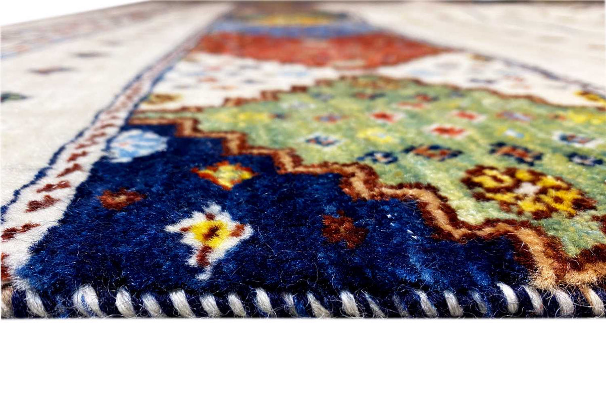 Carpet detail with a colorful central motif and short fringes along the edge