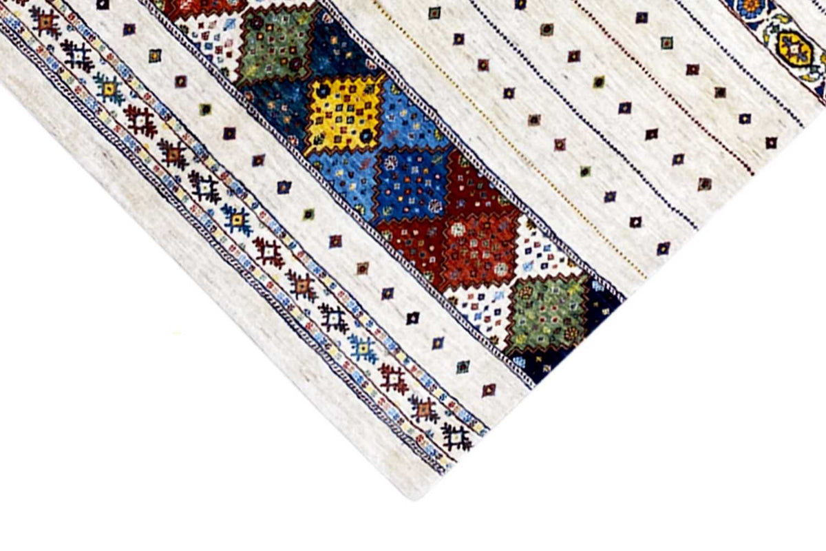 Rug border with a cream-colored background, colorful diamond shapes, and decorative stitching lines