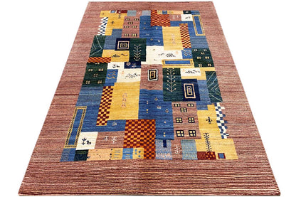 Gabbeh Lori rug shown in three-quarter view with patchwork squares in blue, yellow, and green