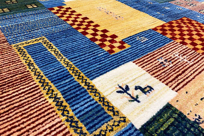 Gabbeh-Lori rug detail with blue stripes, yellow diamonds, and small symbols