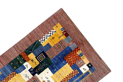 Gabbeh-Lori rug corner with patchwork blocks in blue, yellow, green, and white