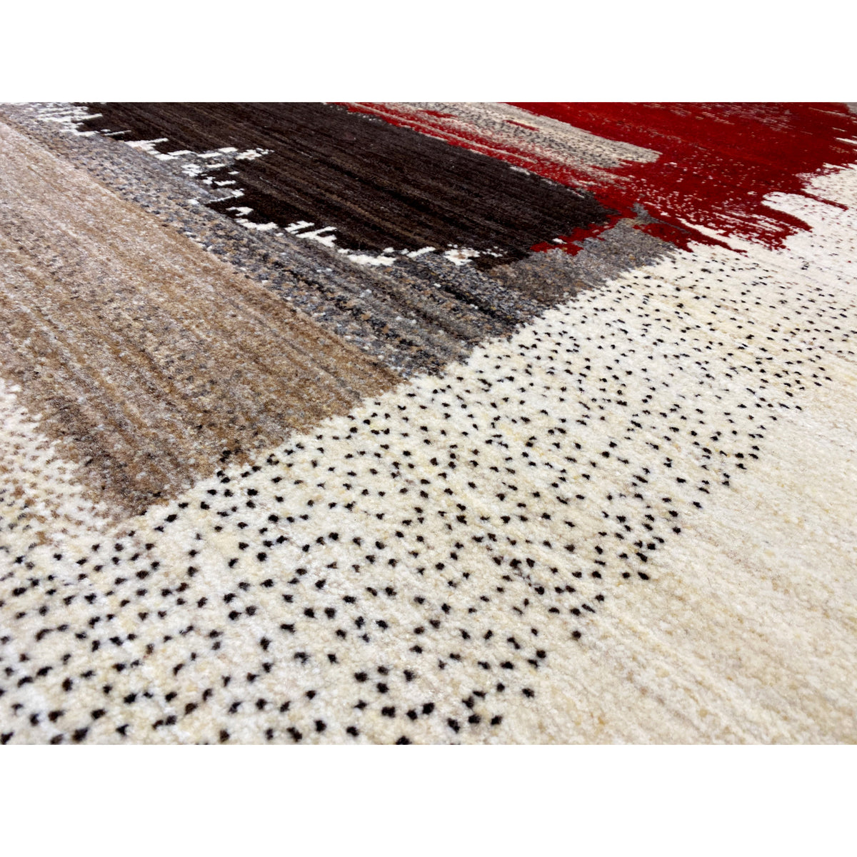 Detailed view of the Gabbeh rug: dotted texture and color blocks in red, black, and beige