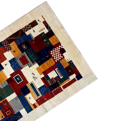 Gabbeh rug corner with patchwork sections and ornamental patterns in beige and blue