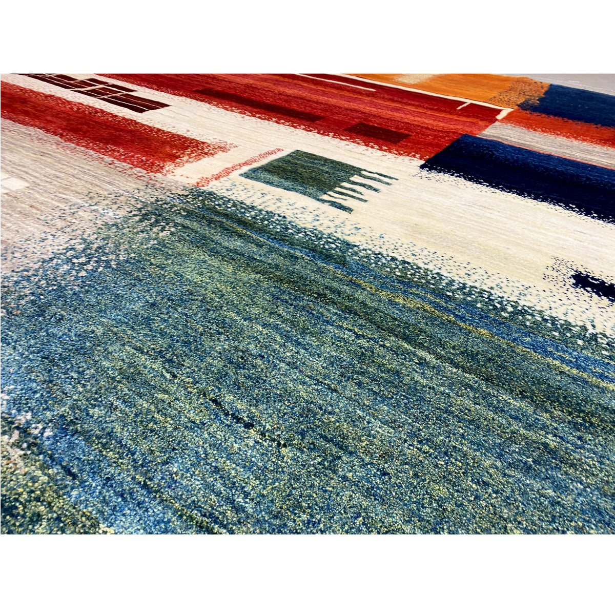 Close-up of a Gabbeh rug: blue-green pile with red and beige stripes