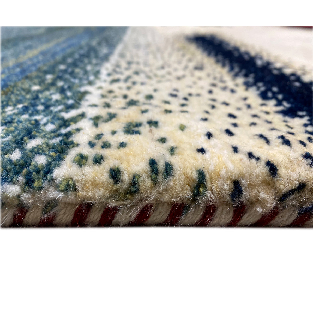 Close-up of a Gabbeh rug with a dense pile, blue, beige, and dark blue accents