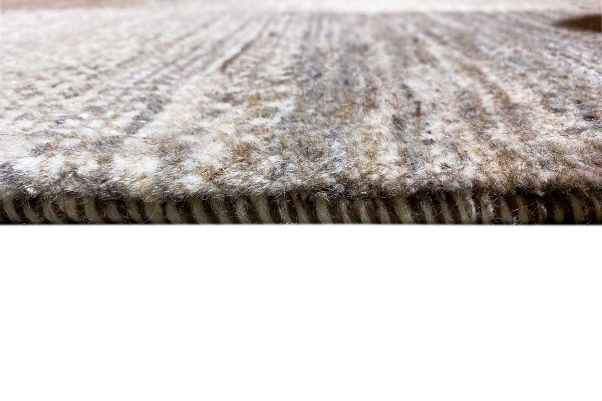Wool rug with fringed edges, mottled gray and cream pattern
