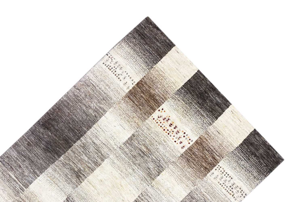 Wool rug with a checked patchwork design in gray, cream, and brown, with red accents