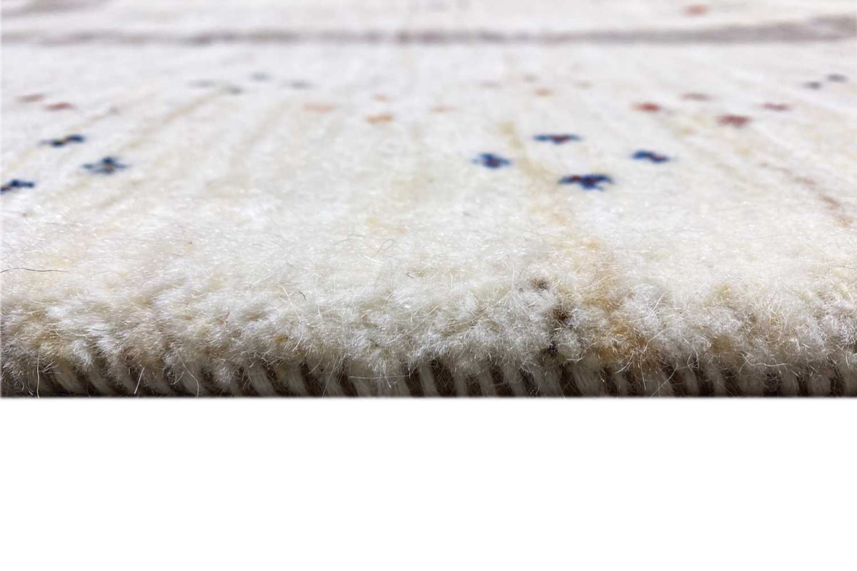 Close-up of the pile of a beige Gabbeh rug with a fine, dense texture