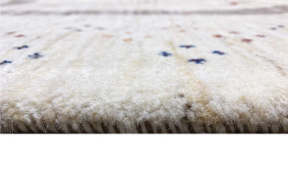 Close-up of the pile of a beige Gabbeh rug with a fine, dense texture