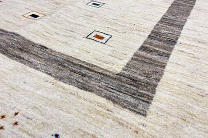 Detail view: beige Gabbeh rug with gray central stripes and small multicolored squares