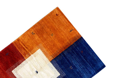 Multicolored Gabbeh rug corner in perspective with an orange-blue block pattern