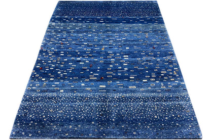 Blue Gabbeh rug with a small geometric pattern, laid out at an angle, rectangular