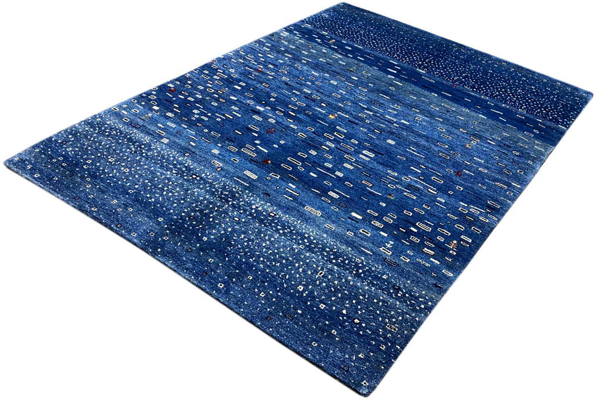 Blue Gabbeh rug with geometric lines and dots, diagonal perspective