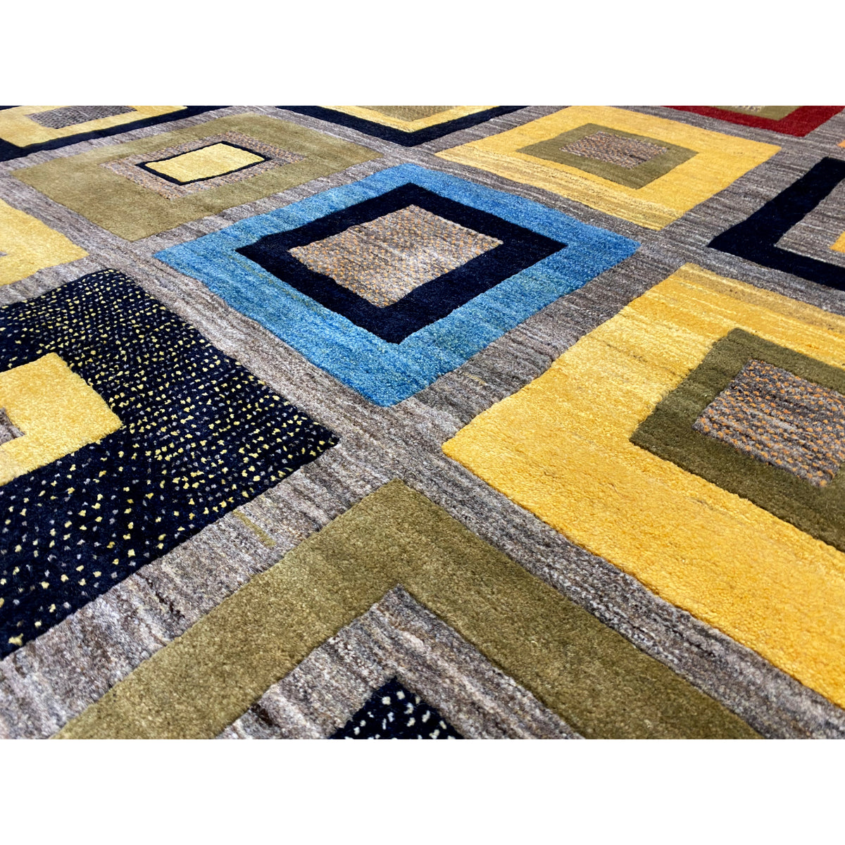 Gabbeh rug close-up: colorful diamonds and squares, textured yarn surface.
