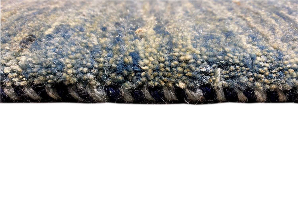 Close-up of the edge of a blue runner: cut pile with a dark underside.