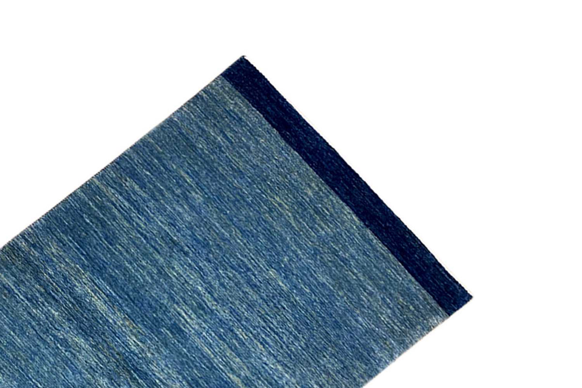 Blue runner rug 100x250 cm with a wide dark border along the side, diagonal view.