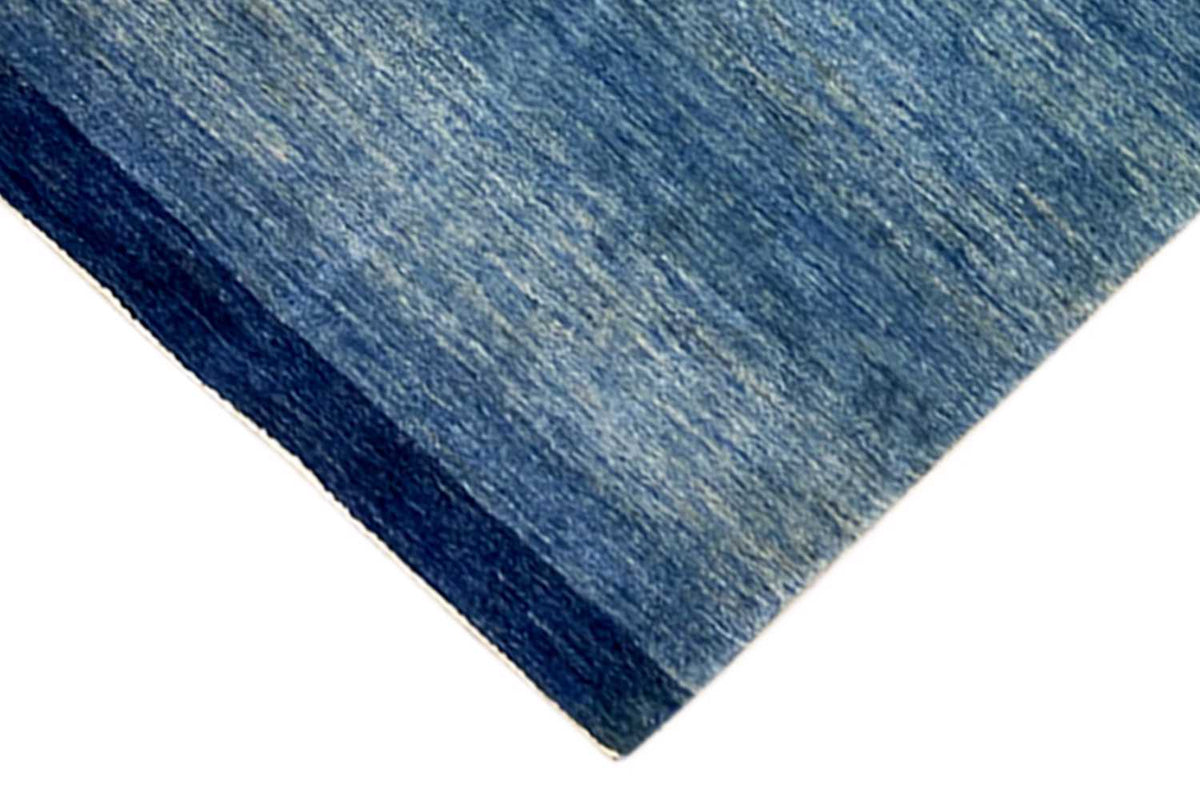 Corner of a blue runner rug measuring 100x250 cm, with a dark border and mottled surface.