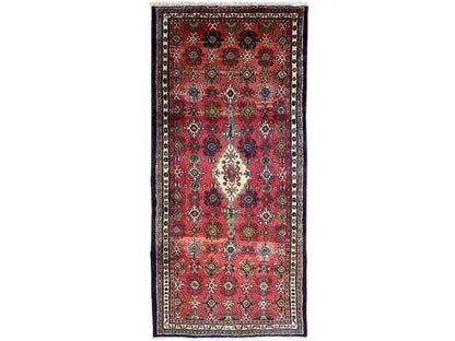 Oriental rug with a red field and blue border, featuring a central medallion