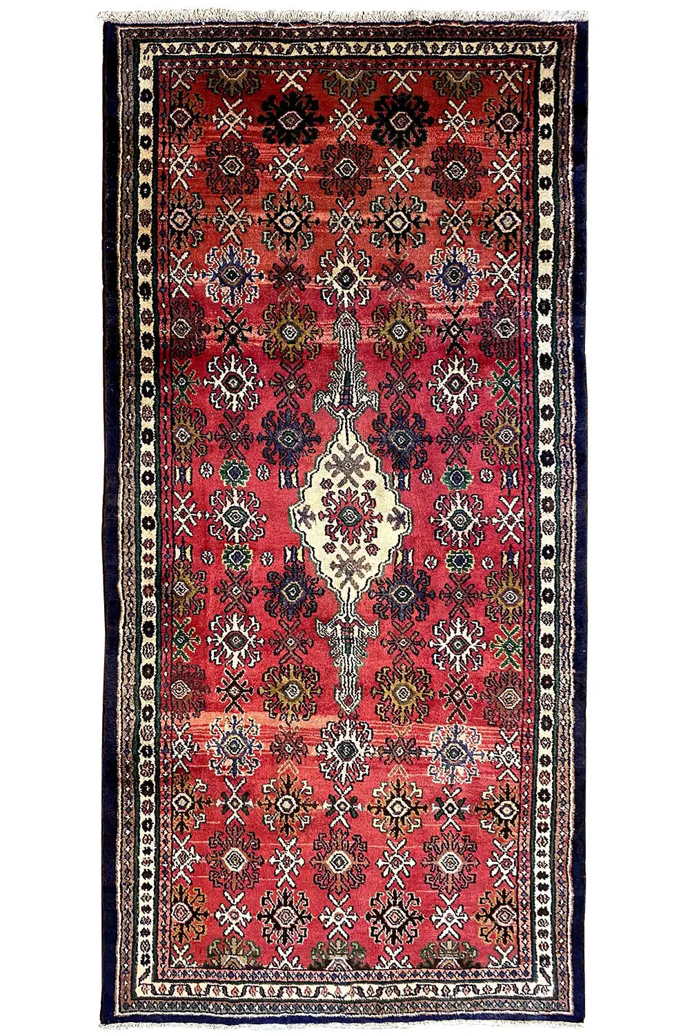 Oriental rug in portrait orientation: red field, blue-and-white border, and central cream-colored medallion