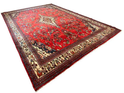 Hamadan rug laid flat: red field with a geometric-floral pattern and border
