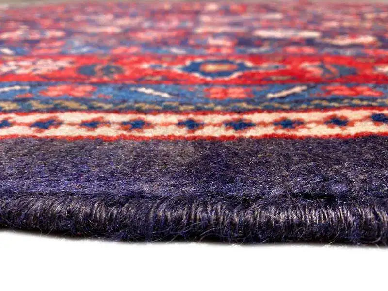 Rug edge with fringe, dark blue pile fabric and multicolored border