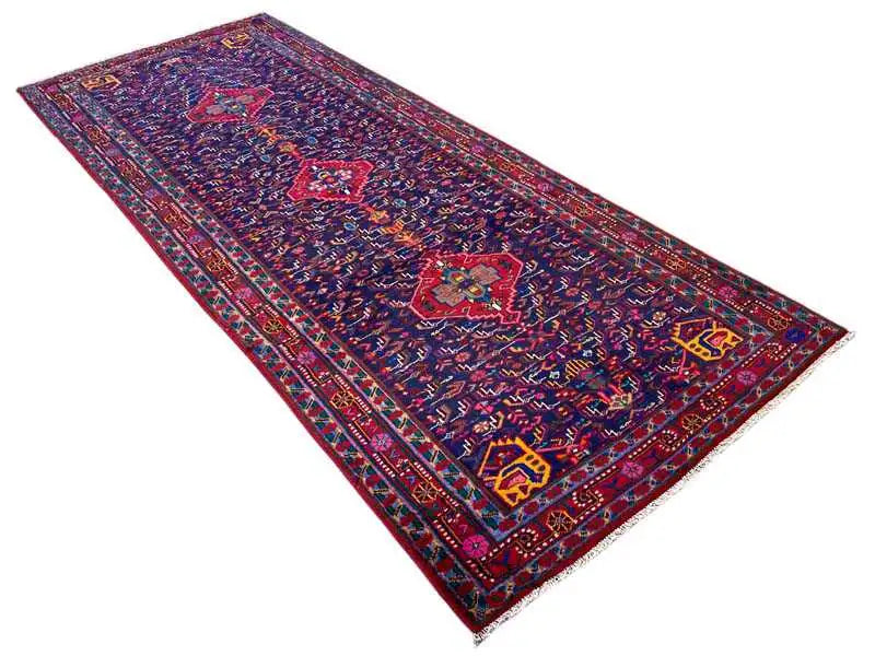 Oriental rug spread out, dark blue with central medallions and multicolored borders