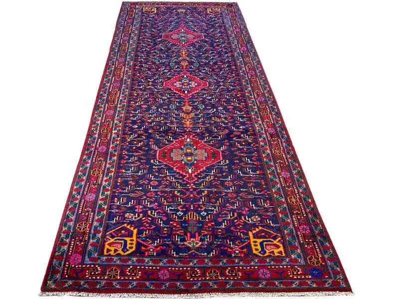 Oriental rug laid flat, dark blue with a symmetrical medallion pattern and borders