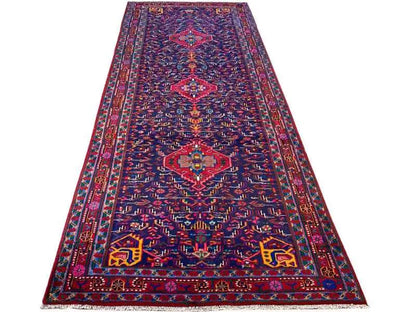 Oriental rug laid flat, dark blue with a symmetrical medallion pattern and borders