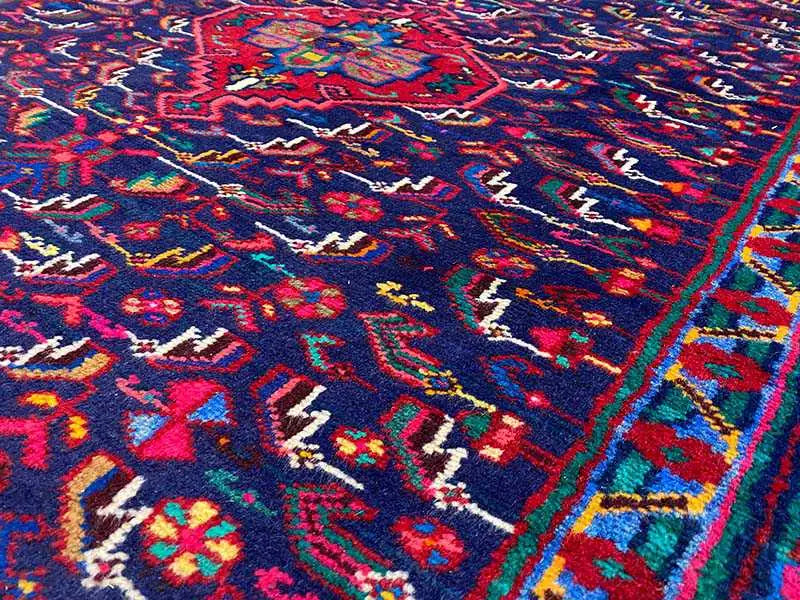 Rug pile with a detailed pattern in blue, red, green and yellow