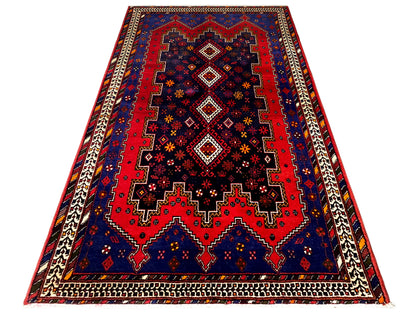 Runner rug in angled view: dark blue, red pattern, beige frame and borders