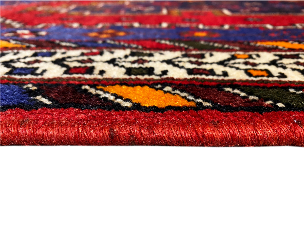 Sirjan runner rug: detail with red pile, colorful pattern, and woven border