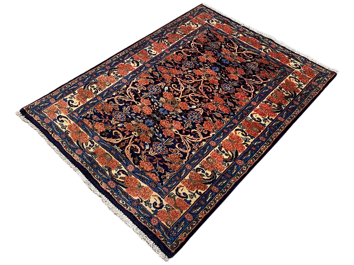 Rug at an angle: dark blue and red ornamental pattern with border, 142×102 cm